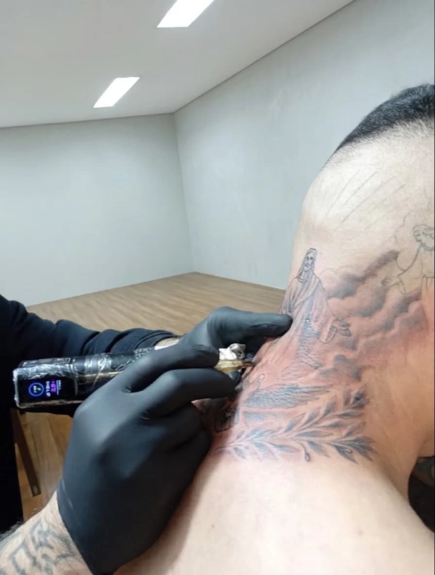 Tatuagem religiosa na nuca em andamento