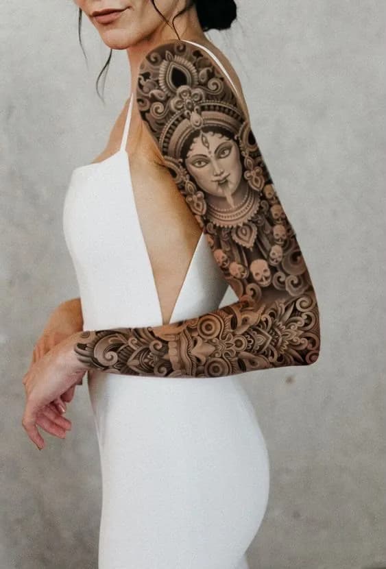 Tatuagem de deusa hindu com composição ornamental em blackwork no braço fechado
