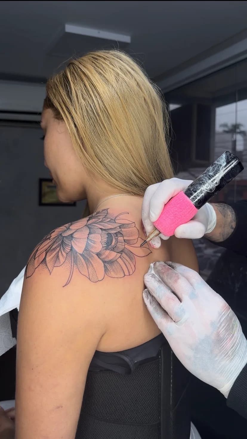 Tatuagem floral delicada em fine line no ombro